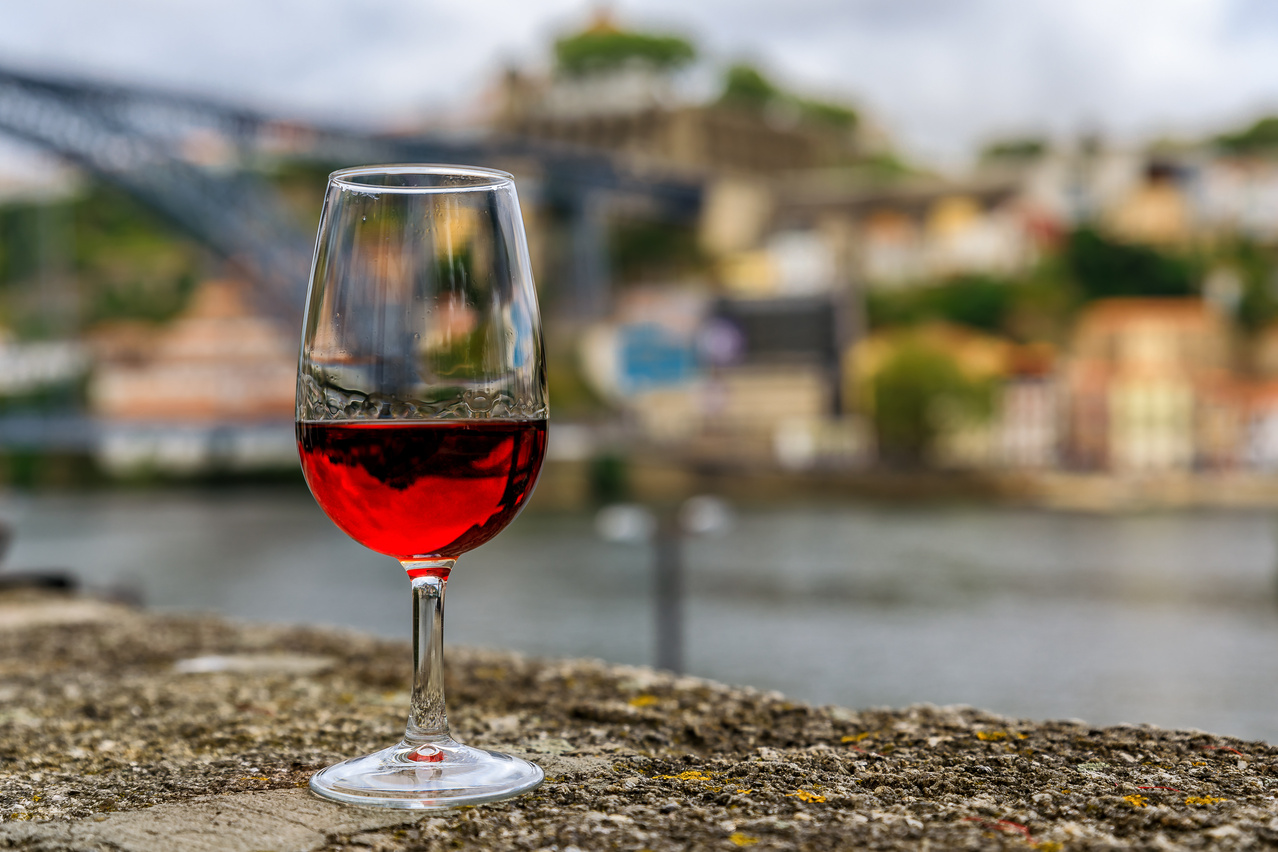 Glass of port wine with the blurred cityscape of Porto Portugal in the background