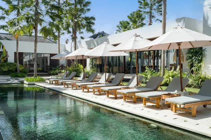 Sun loungers and umbrellas along the villa pool