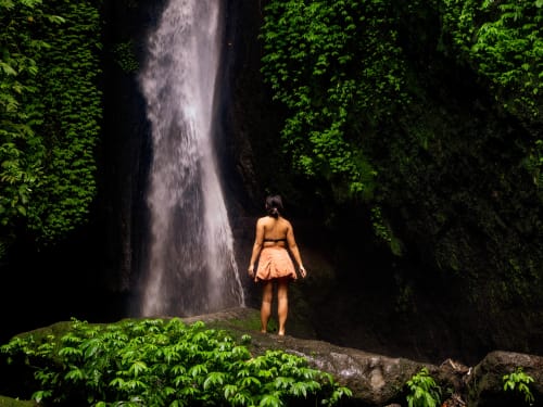 A guest standing beneath a waterfall