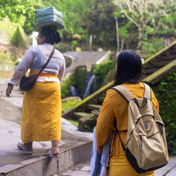 Guests in sarongs climbing temple steps