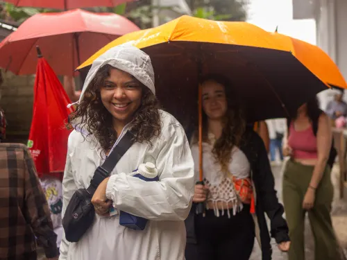 Guests laughing under umbrellas in Ubud in the rain