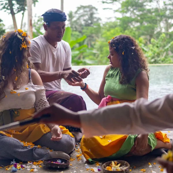 Guests receiving flowers during a blessing by the pool