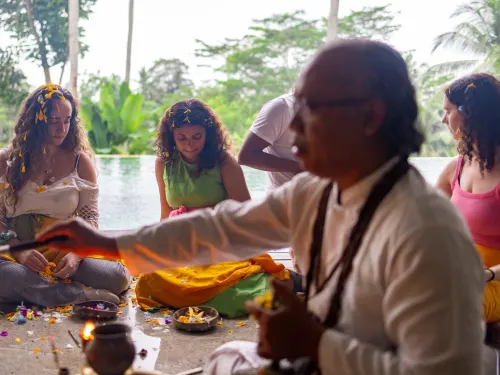 A priest leading the Agni Hotra fire ceremony by the pool