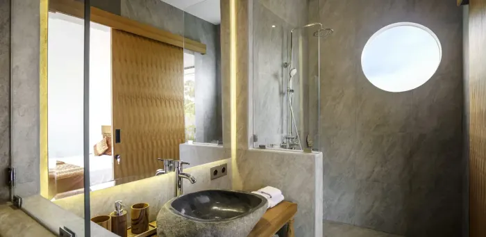 An ensuite bathroom with a stone basin and walk-in shower